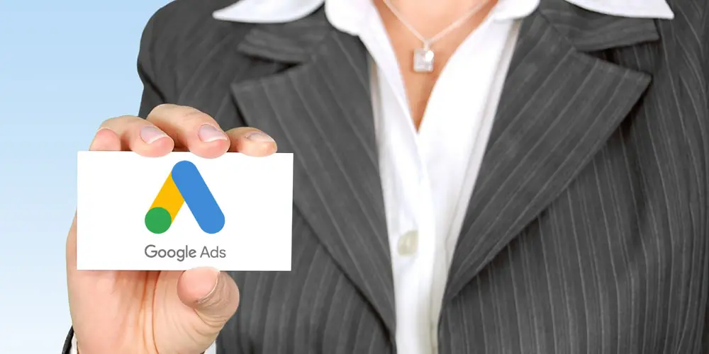 Imagem mostra uma mulher segurando cartão com a logo do Google ads